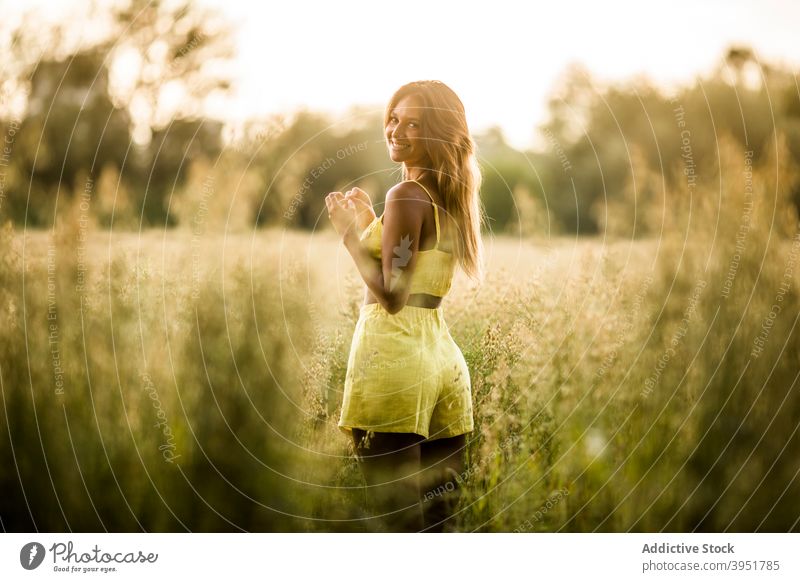 Woman walking in field in summer woman tranquil carefree touch grass park meadow female salburua vitoria gasteiz spain nature weekend calm harmony outfit yellow
