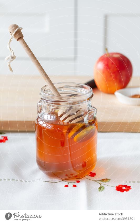 Jar of honey near board with apple table kitchen home cook spoon jar cutting board dessert sweet glass ingredient snack ripe yummy food fresh fruit tasty