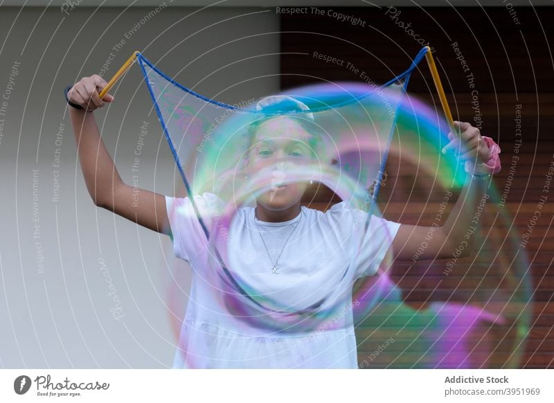 Excited black teen girl playing with colorful soap bubbles woman having fun cheerful excited joy playful enjoy positive happy female young african american