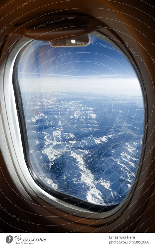 Such a good feeling to be above the clouds. Comfy on a plane in your seat. Watching some snowy mountains passing by. Winter holidays are here! airplane window
