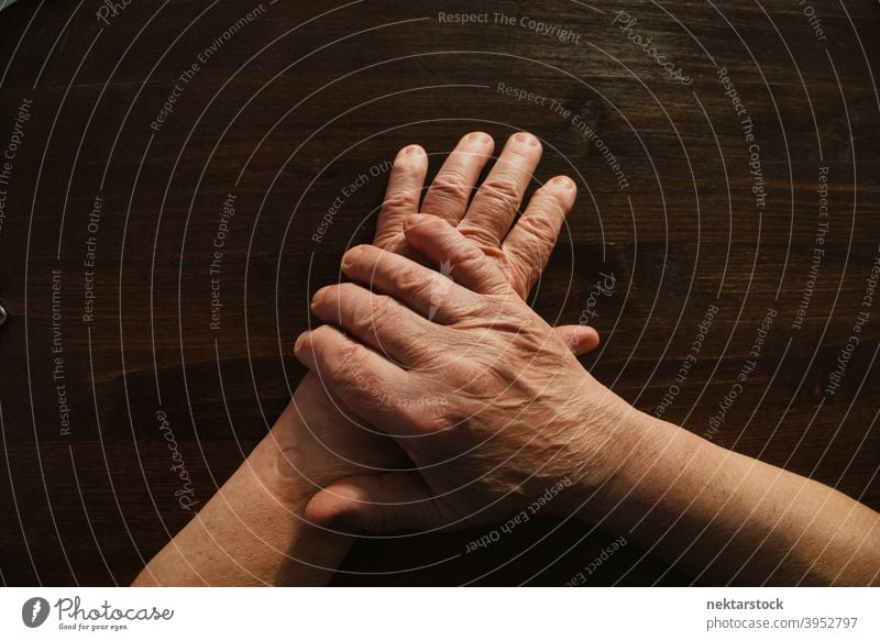 Hands and Arms of Old Man on Wooden Surface hand old finger male man arm high angle view unrecognizable person limb indoor professional lighting body part