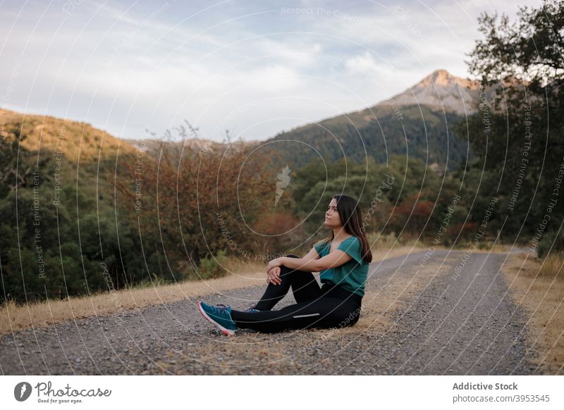 Young woman resting on road during hiking in highlands traveler mountain relax freedom hike adventure nature young female spain grazalema journey lifestyle