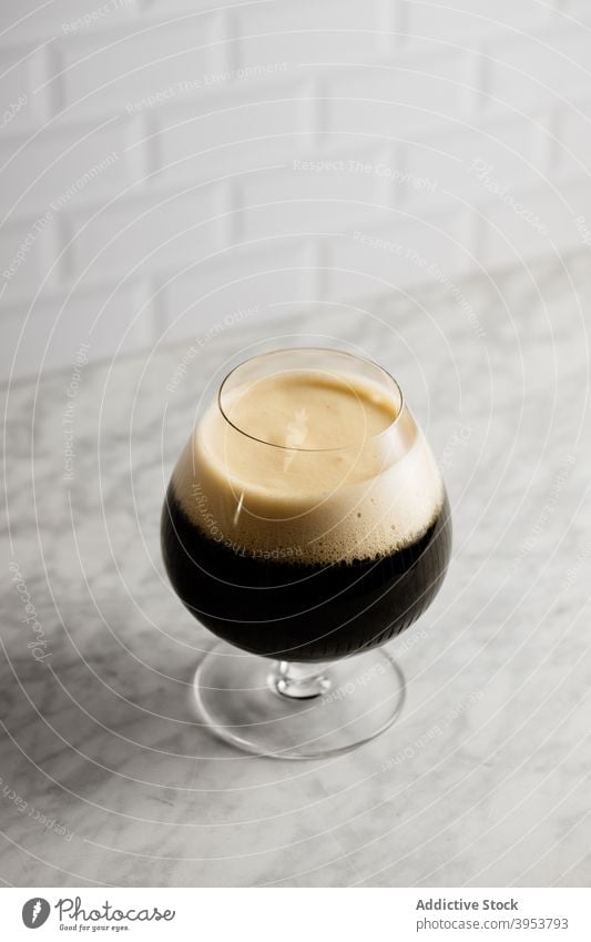 Glass of dark beer on marble table stout alcohol drink bar beverage ferment glass craft tradition wooden stone booze style cold liquid foam froth fresh
