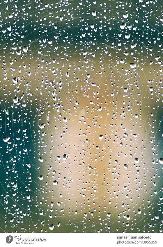 raindrops on the window in rainy days water wet abstract background textured lights colorful street outdoors colors bright winter