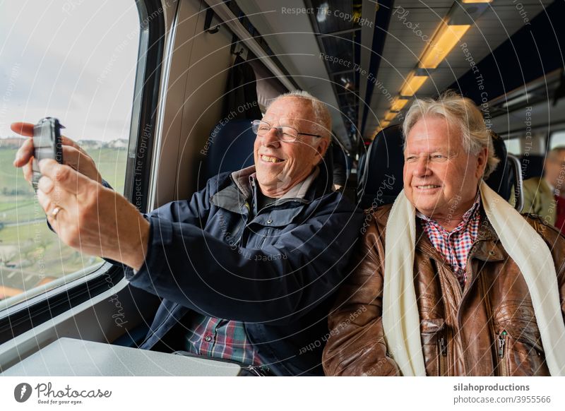 Older men making a selfie in train. pensioner portrait person adult elderly happy face people hands retirement age retired laugh dental tooth man pleasure