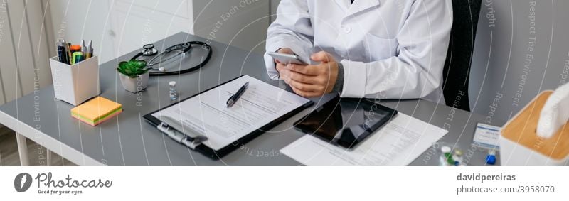 Female doctor using mobile while working female doctors office texting chatting medical banner web header panorama panoramic unrecognizable care medicine