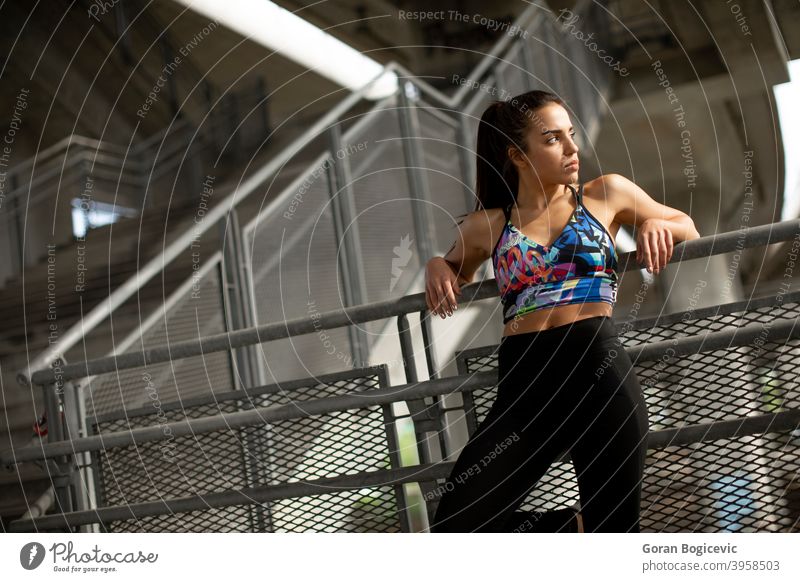 Young fitness woman taking a break from running in urban environment athlete beautiful city cityscape concrete exercise female hair happy health healthy leisure