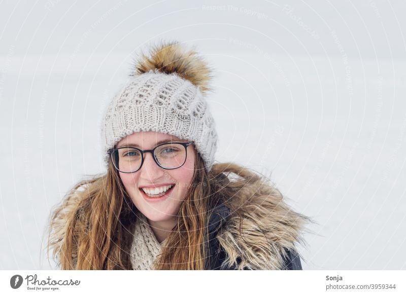 Young smiling woman with glasses and wool cap Woman youthful Eyeglasses Smiling Winter Snow Woolen hat long hairs Curly Brunette portrait see Joy pretty