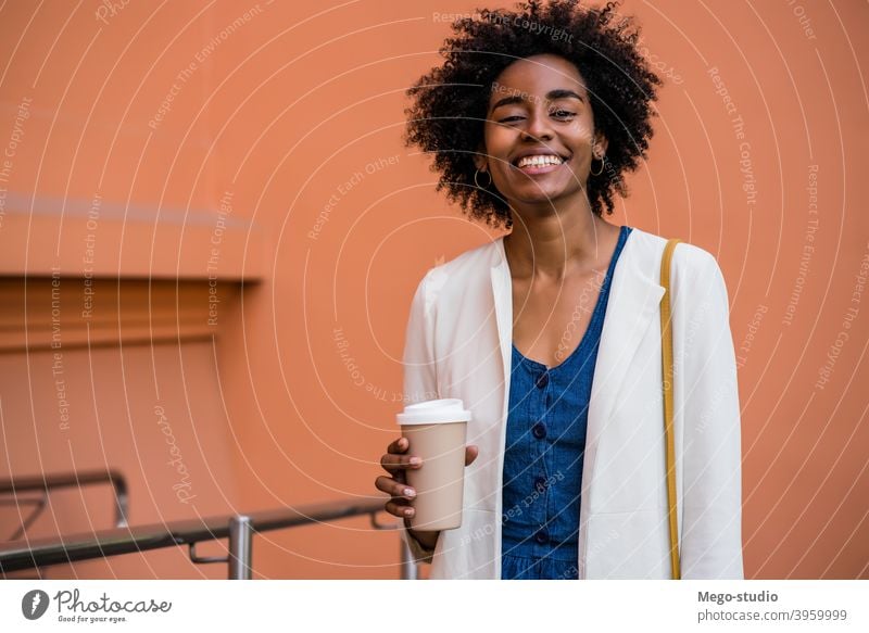 Afro business woman holding a cup of coffee outdoors. afro urban smile adult take away coffee suit company businesspeople executive portrait standing success