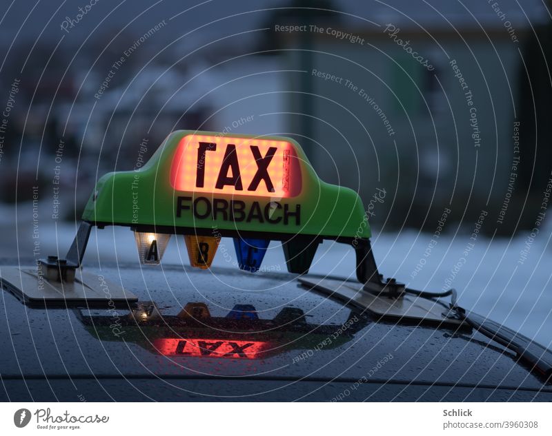 Defective light on a taxi from Forbach Lorraine with inscription rax or tax and reflection in the rain wet tin roof taxi sign Taxi Rainy weather broken Text