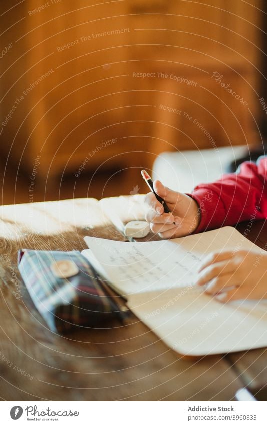 Kid doing homework at table kid write schoolchild assignment education study learn pencil hand copybook knowledge task pupil diligent smart take note clever