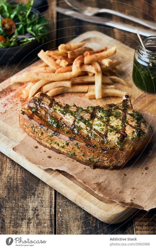 Grilled beef steak with French fries on table dish serve meat cafe french delicious exquisite appetizing wooden cutting board chopping board fresh gourmet