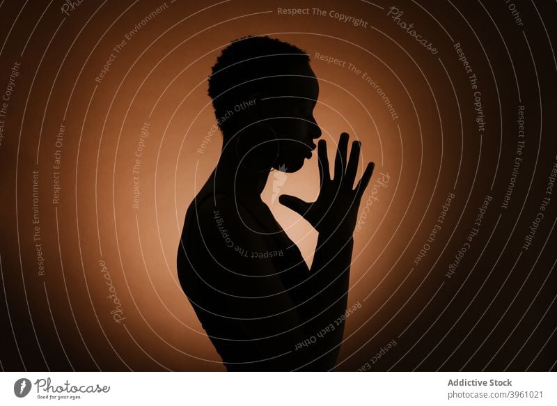 Unrecognizable black woman praying with clasped hands hands clasped dark gesture silhouette hope spirit faith wish female model ethnic african american harmony