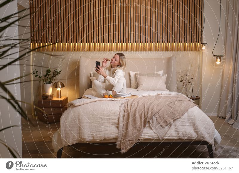 Woman taking selfie during breakfast in bedroom woman smartphone morning food home self portrait female device gadget young take photo rest memory online