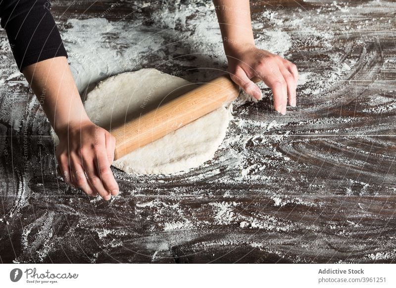 Woman rolling dough on table rolling pin bread baker food prepare flour bakery hand kitchen culinary female cook pastry cuisine chef process meal product