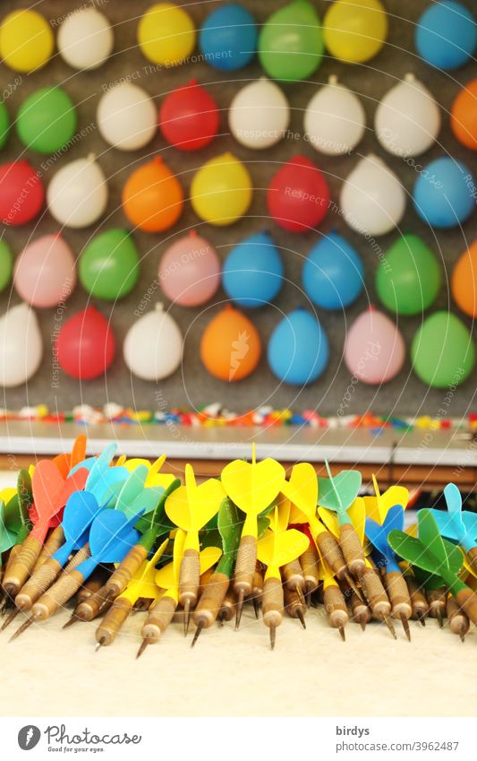 Shooting booth with coloured balloons and darts at a funfair Shooting gallery Fairs & Carnivals variegated Darts Showman Theme-park rides Feasts & Celebrations