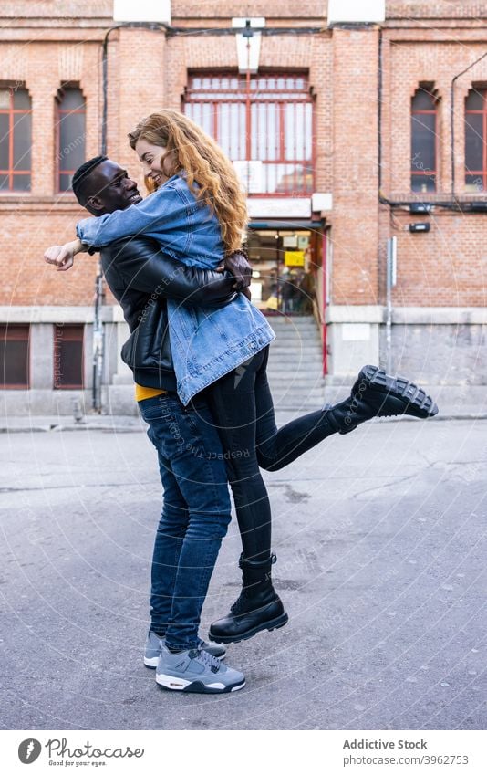 Happy multiracial couple hugging in city cuddle street together boyfriend girlfriend love relationship affection multiethnic diverse black african american