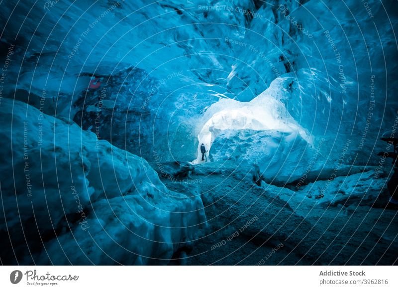 Explorer in ice cave in winter traveler explore frozen cold vacation adventure scenery iceland frost nature north tourist climate rock freeze wanderlust journey