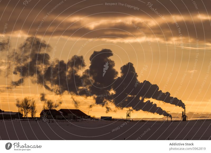 Scenery of smoke from chimneys in countryside sky winter industry industrial fume cloud sunset iceland building settlement landscape dusk snow house scenic cold