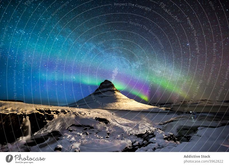 Scenic northern lights at night in mountainous terrain aurora aurora borealis winter sky starry polar iceland snow majestic nature rock rocky peak illuminate