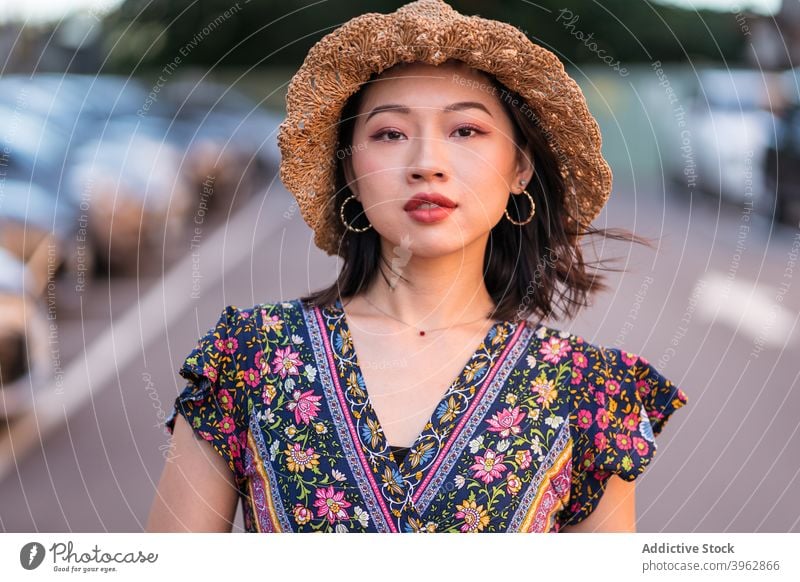 Stylish ethnic woman on parking lot style trendy dress outfit straw hat wicker handbag summer female asian charming fashion stand content apparel attire city