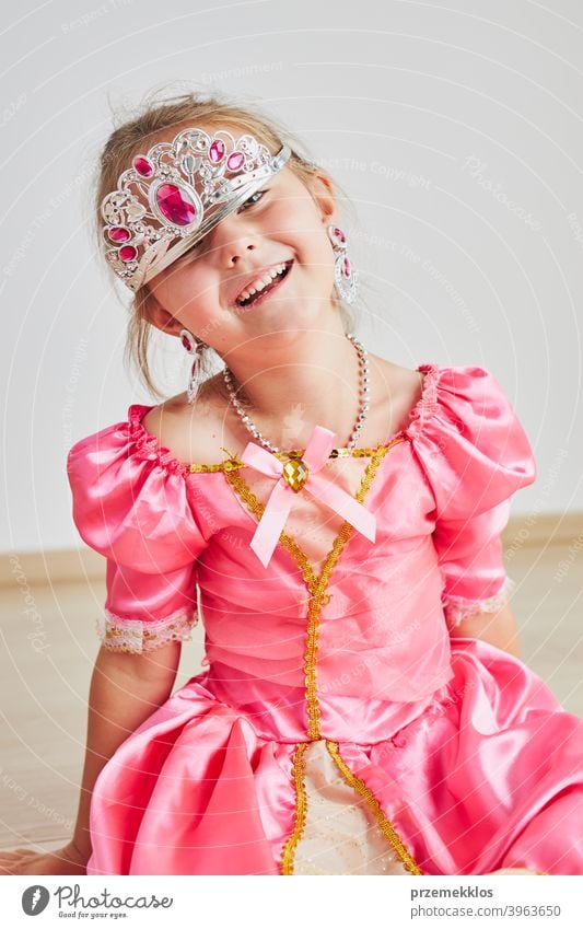 Little girl enjoying her role of princess. Adorable cute 5-6 years old girl wearing pink princess dress and tiara fairy child festival lifestyle joyful smiling