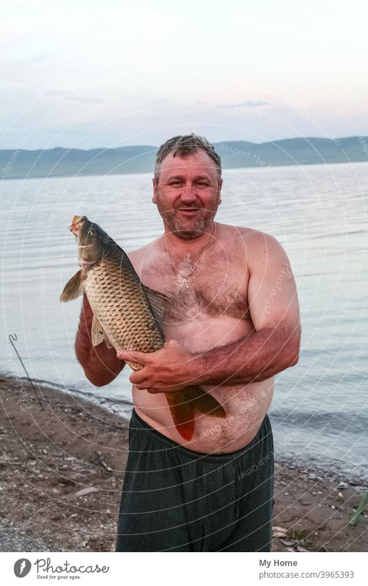 Stocky man with fish. Khakassia, Russia - a Royalty Free Stock