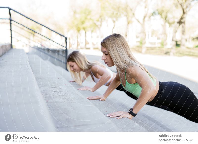 Slim athletes doing push ups in city sportswomen workout training slim stair exercise slender female concrete fit physical wellbeing determine practice