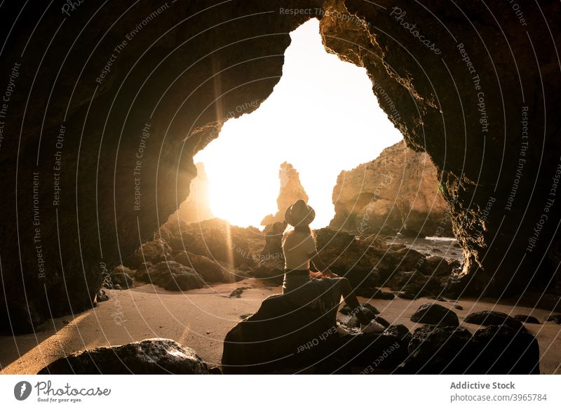 Unrecognizable woman admiring cave near sea admire vacation sunny daytime travel algarve portugal female hat casual ocean idyllic rock stone tourism journey