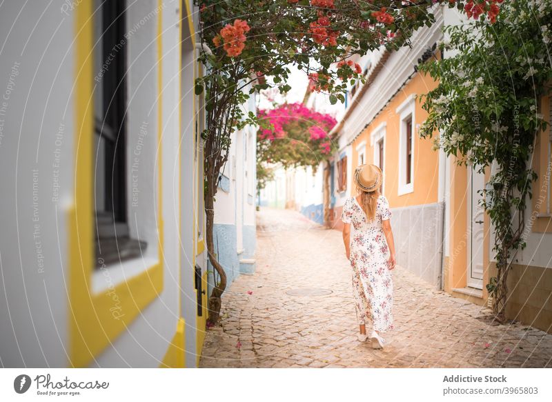 Faceless elegant lady waling on street near cozy colorful houses during holidays in Portugal woman walk district explore traveler sightseeing flower summer