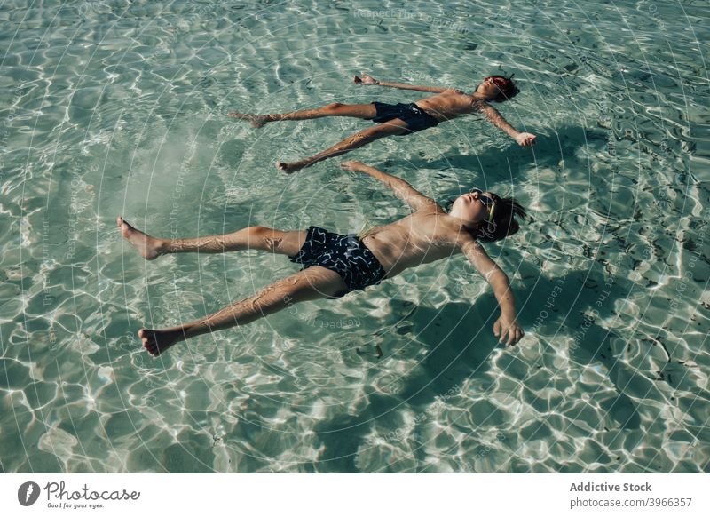Two boys relaxed on the beach in summer child resting sea water aqua beach kids blue caucasian childhood enjoy european goggles happiness happy little ocean