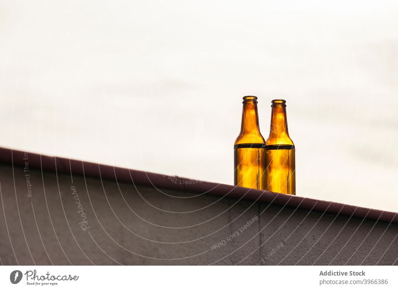 Pair of beer bottles on balcony wall party leisure terrace summer city outdoors drink rooftop alcohol sunset celebration concept celebrating outside two
