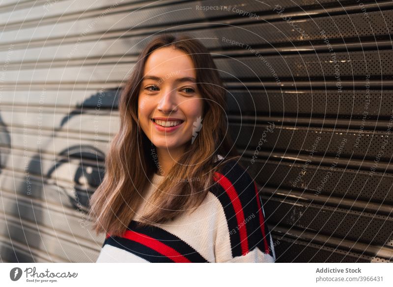 Cheerful young woman standing near wall happy cheerful teenage smile optimist glad positive female adolescent millennial brunette joy lifestyle delight glee