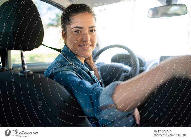 Woman driving her car and looking at back seat young woman business businessman cab professional travel city transportation taxi urban service vehicle road