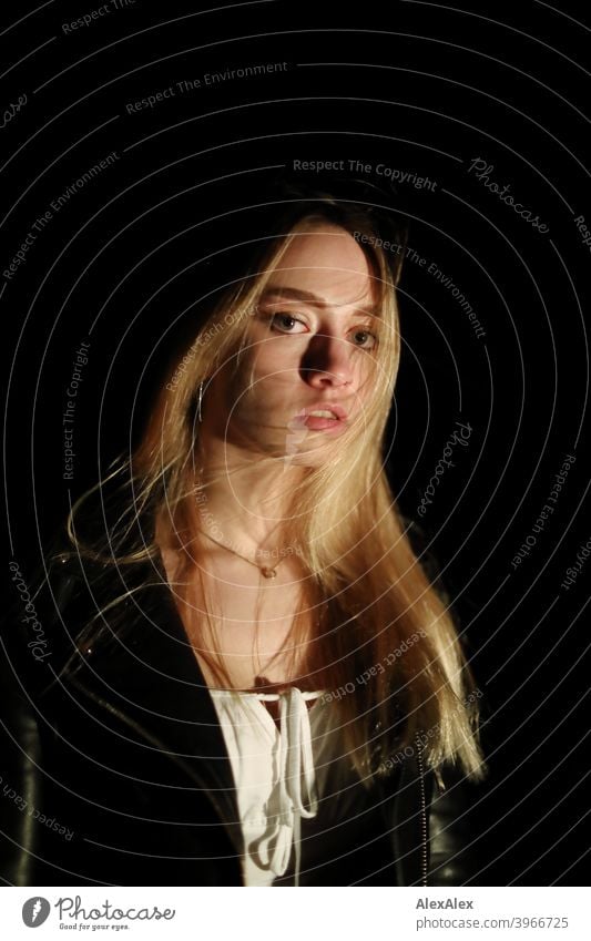 Portrait of a young long haired woman in the dark Woman young maiden Girl Slim Blonde Long-haired blowing hair Dark at night Night portrait laterally pretty