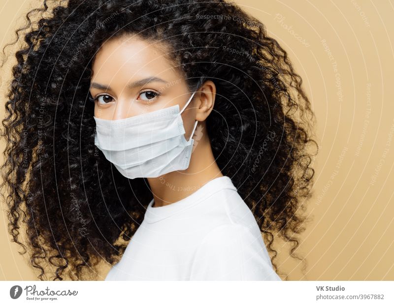 Photo of dark skinned Afro American woman with curly bushy hair, surgical american girl medical clinic safety emergency face photo horizontal background working