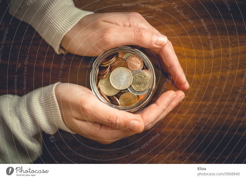 Hands holding a jar full of coins. Saving. Coin Save Money Bird's-eye view Glass Money box Euro Loose change Coins stop small livestock small change Wood assets