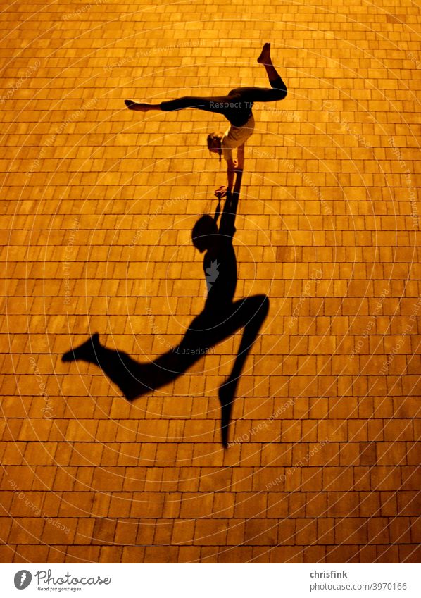 Gymnast at night with shadow Shadow Light Structures and shapes Contrast Exterior shot Gymnastics Colour photo Handstand Splits contorsion Movement