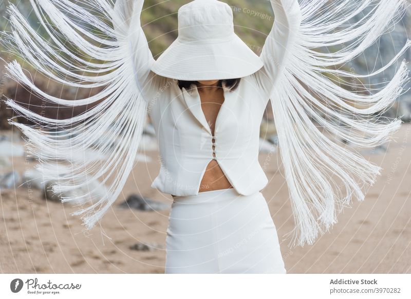 Fashionable woman in stylish white clothes with wings shaped sleeves fashion style elegant outfit model fly suit hat female trendy slim vogue feminine grace