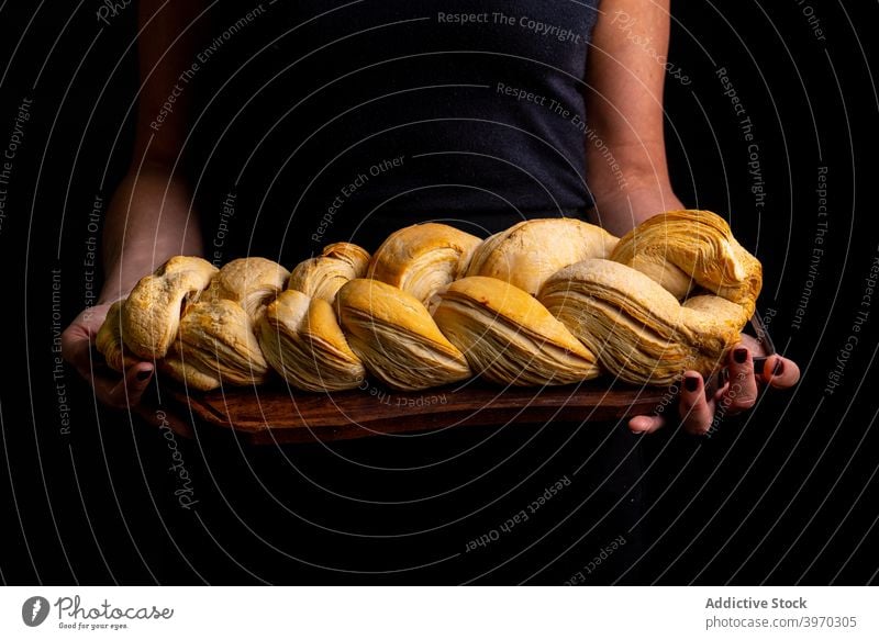 Woman with artisan braided bread loaf puff baker board bakery woman bun dark delicious cuisine crust tasty cook organic tradition culinary baked gourmet product