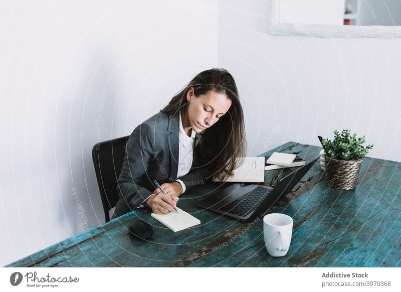Businesswoman making notes during workday at home businesswoman take note write remote freelance busy plan formal workplace entrepreneur young job lifestyle