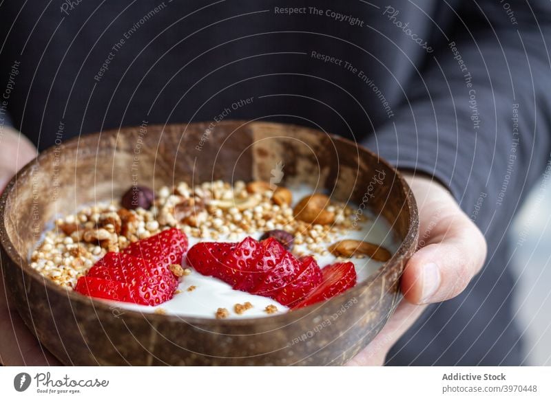 Crop person with breakfast bowl super food healthy morning delicious yogurt berry granola nut nutrition nutrient strawberry sweet cereal muesli fresh meal tasty