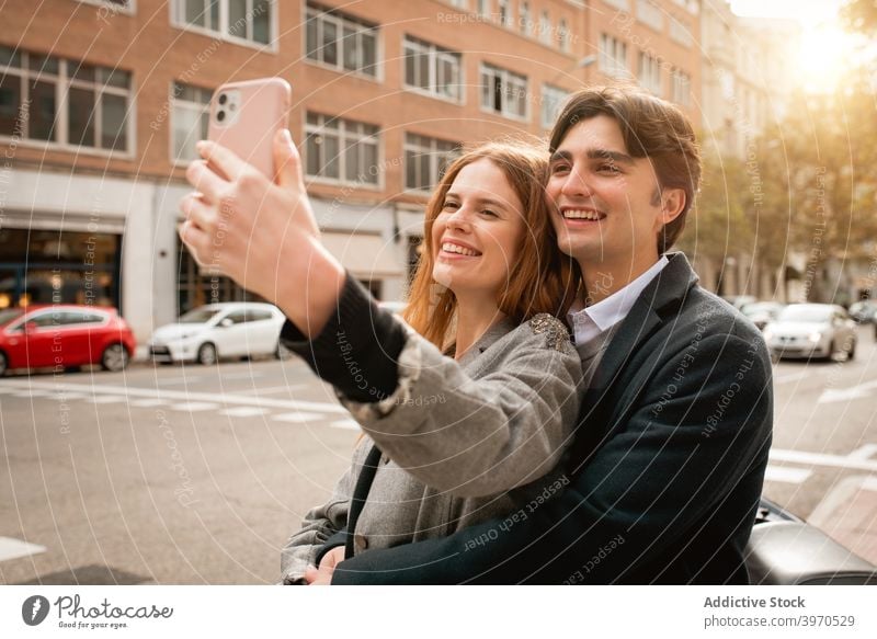 Loving young couple taking selfie on street love together happy smartphone relationship embrace girlfriend boyfriend cheerful lifestyle romantic affection date