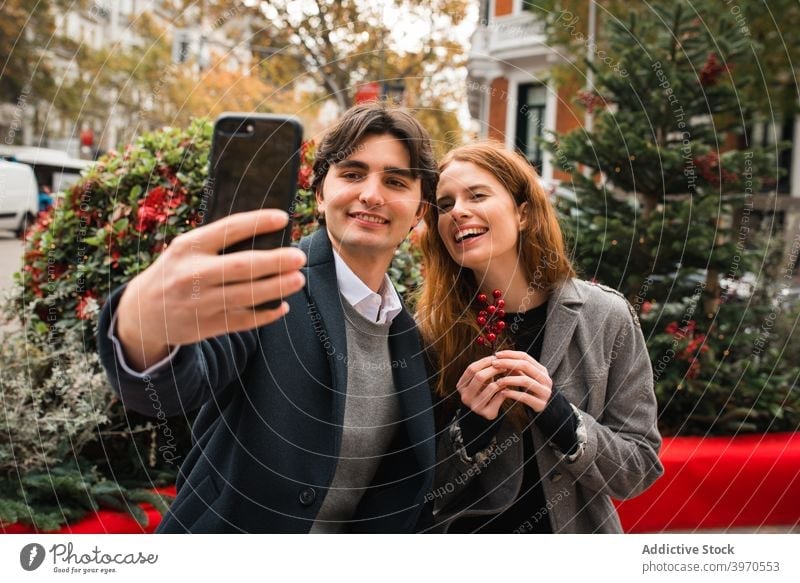 Cheerful romantic couple taking selfie on city street love together happy autumn smartphone young relationship cheerful girlfriend boyfriend lifestyle affection