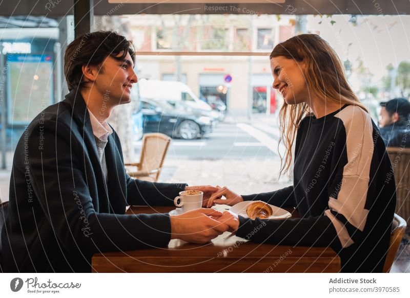Happy couple having date in cafe love together happy romantic affection young window relationship positive cheerful holding hands lifestyle enjoy fondness smile