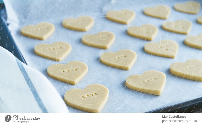 Heart shaped cookies with the word LOVE ready to bake. Pastry Concept. valentine gift cheerful dating valentine's day letters raw baking tray heart shapes line