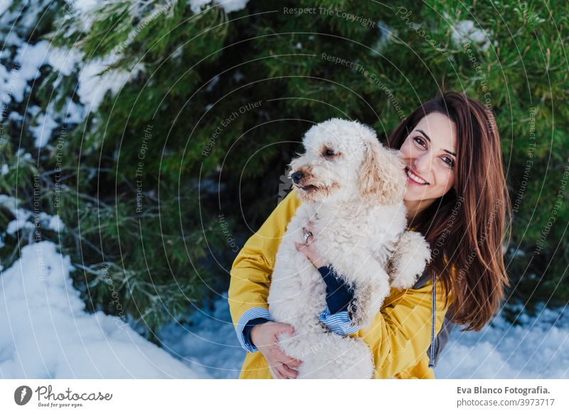backpacker woman hiking outdoors with cute poodle dog. Snowy mountain in winter season. nature, pets and lifestyle snow yellow coat happy smiling travel daytime