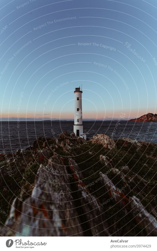 A lighthouse on the Spanish coast during the witching hour in wide angle with copy room imagination Help Inspiration backgrounds Horizontal Motive Michigan USA