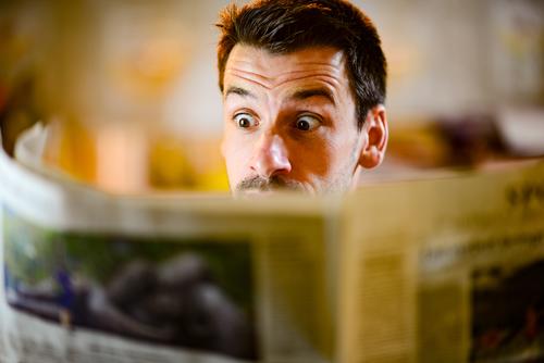 Man looks surprised in the newspaper Newspaper Reading astonished Media Press Current information world Facial expression Amazed shocked