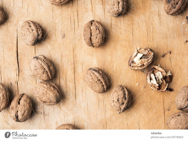walnut in shell on a wooden table whole background broken brown closeup cracked food fresh fruit group hard healthy ingredient kernel natural nature nutrition